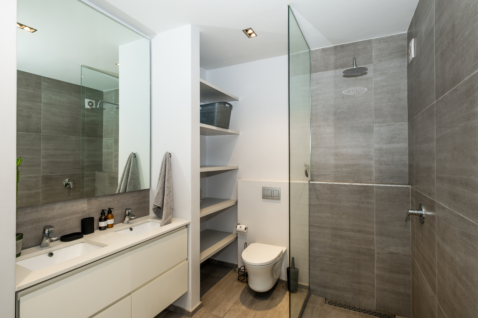 Bathroom with double vanity, rain shower and stone tile