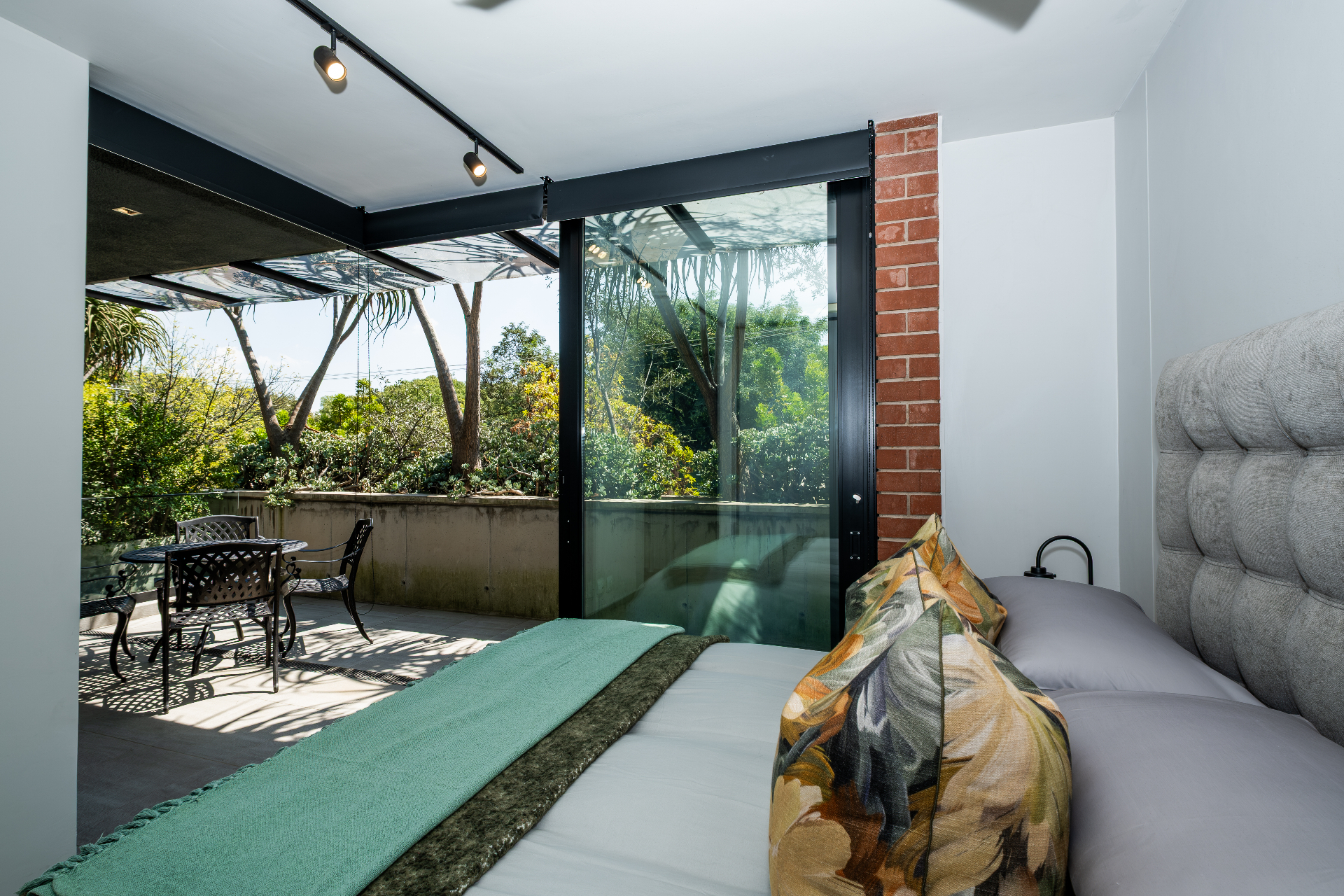 Bedroom opening onto private terrace with garden views