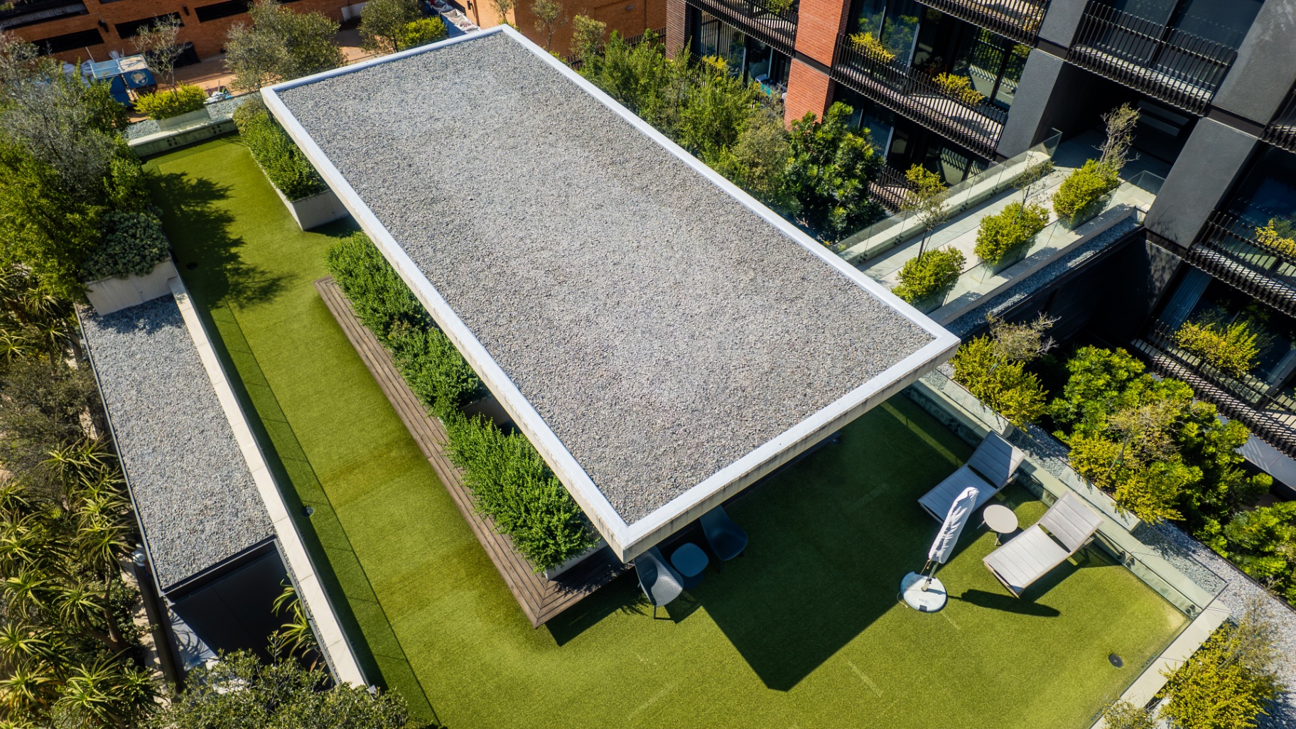 Aerial view of the rooftop lawn and shaded resident lounge