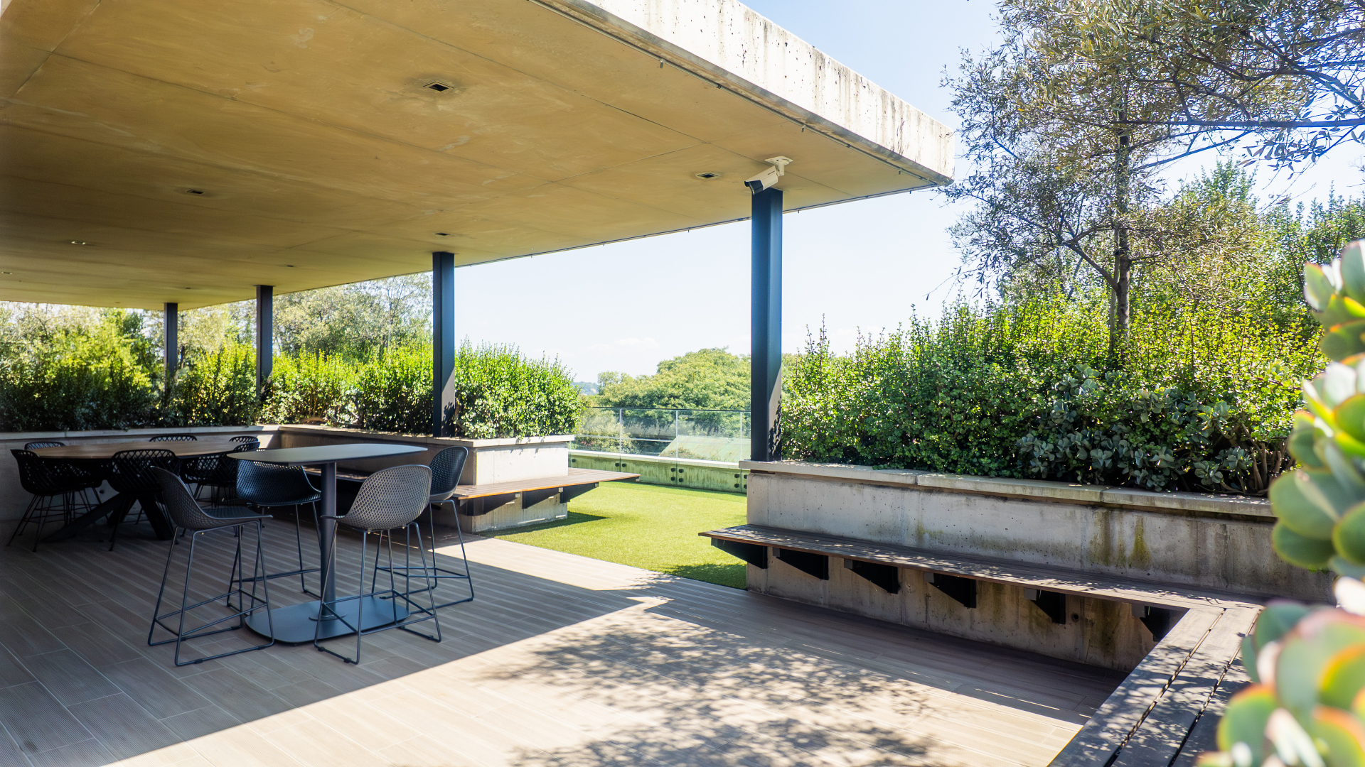 Shaded rooftop deck with bar seating and treetop views