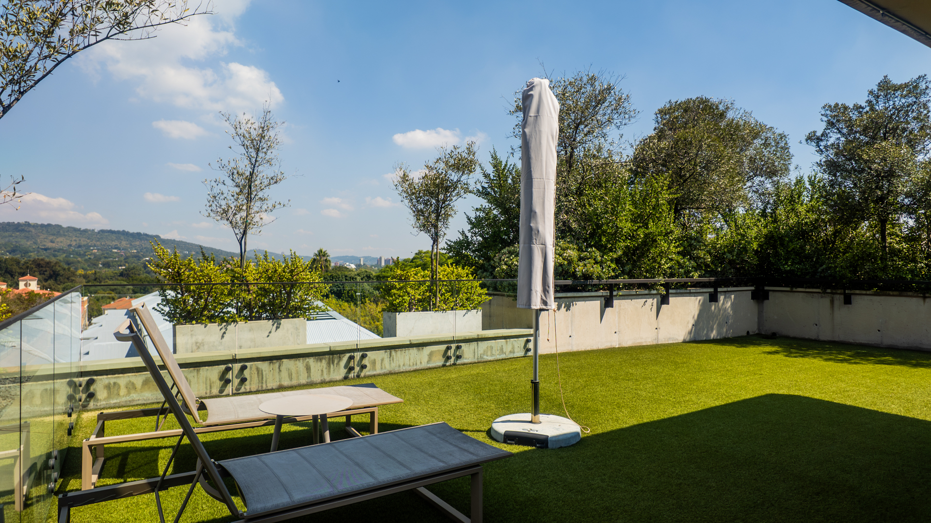 Rooftop loungers on the lawn with open skyline views