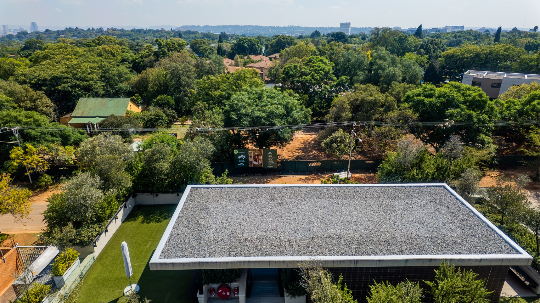 Aerial rooftop view over the tree-lined neighborhood and skyline